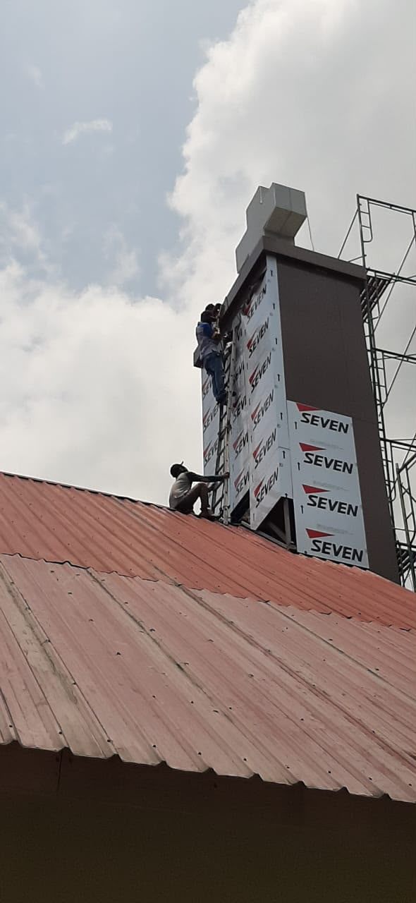 Teknisi mengerjakan panel ACP pada bagian atas bangunan