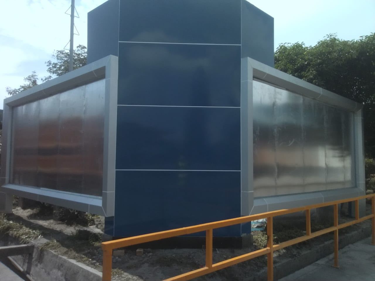 Fasad bangunan dengan panel ACP biru dan bidang kaca