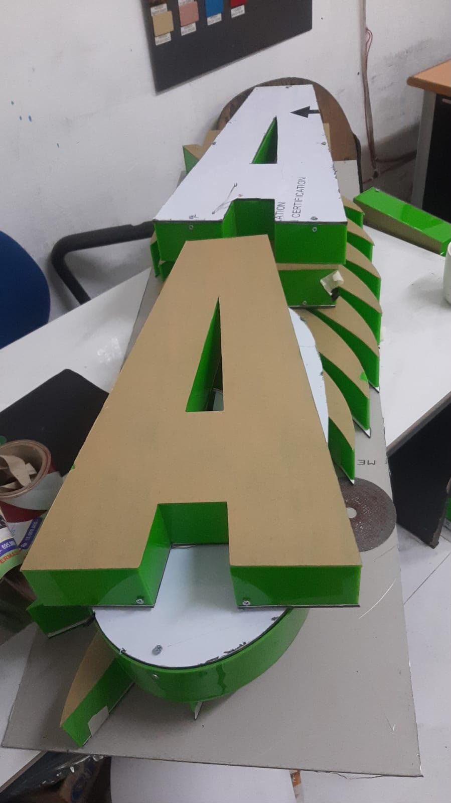 Huruf timbul berbahan panel yang sedang disiapkan untuk papan nama